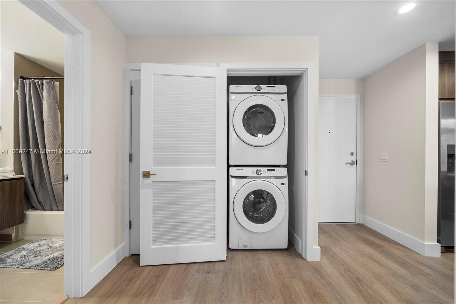 A stacked washer and dryer unit is located in a closet next to a bathroom — 1938 Jackson St # 306, Hollywood FL 33020, HOLLYWOOD, FL