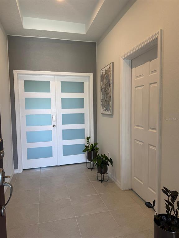 An entryway features a double door with frosted glass panels, tile flooring, and a closet door — 1791 SMARTS RULE STREET, KISSIMMEE, FL