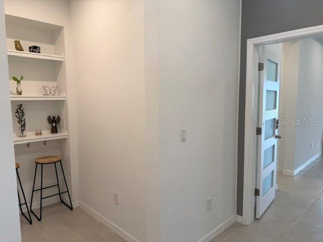 A small alcove features built-in shelving, two bar stools, and a doorway with a glass door — 1791 SMARTS RULE STREET, KISSIMMEE, FL