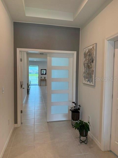 A hallway features light tile flooring, a gray accent wall, and a modern frosted glass door — 1791 SMARTS RULE STREET, KISSIMMEE, FL