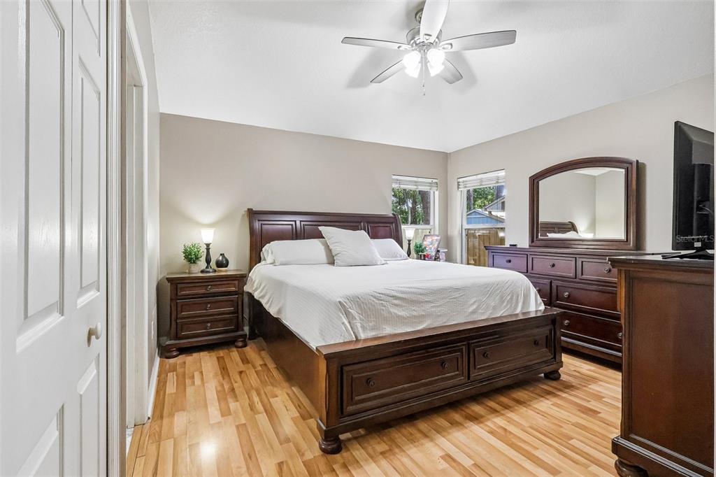A bedroom features a wooden bed frame, matching dresser with mirror, and light wood flooring — 619 CORAL WAY, WINTER SPRINGS, FL