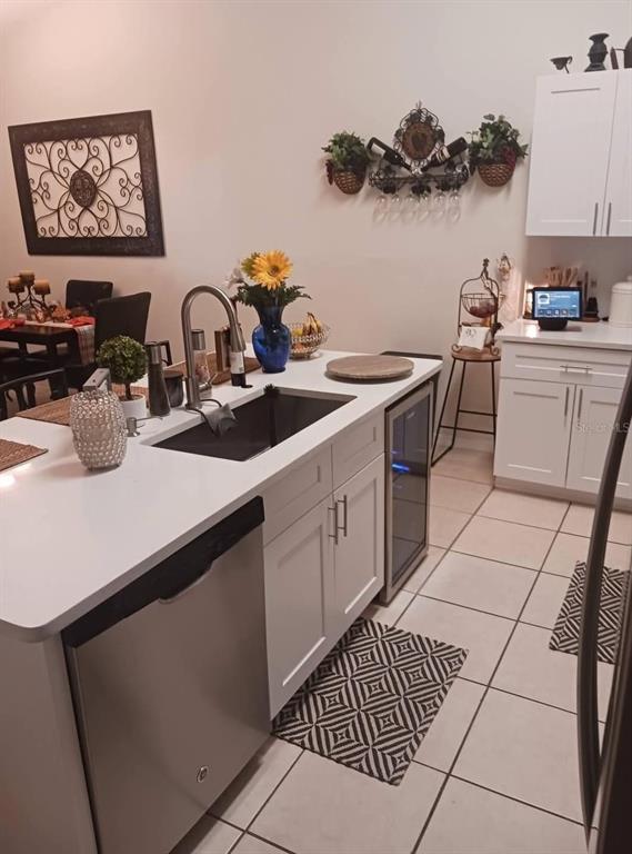 A kitchen island with a sink and dishwasher sits in front of white cabinets — 2409 MING COURT, KISSIMMEE, FL
