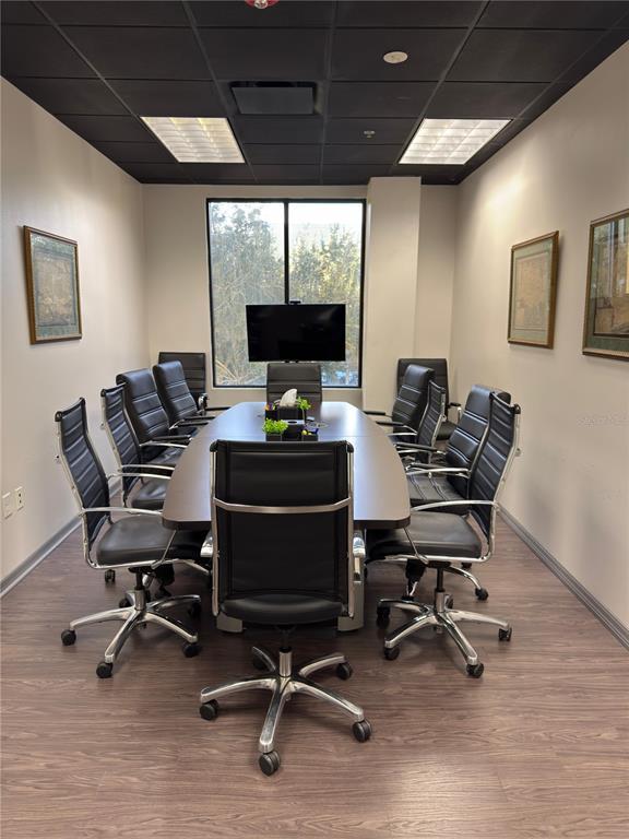 A conference room features a long table, black leather chairs, and a windowed wall — 6735 CONROY ROAD UNIT 201, 203, ORLANDO, FL