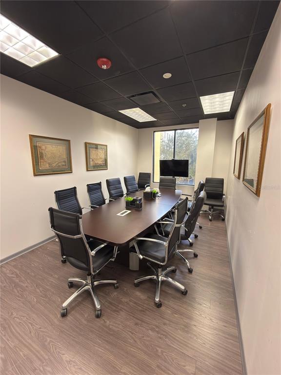 A conference room features a long wooden table, black office chairs, and a dark ceiling — 6735 CONROY ROAD UNIT 201, 203, ORLANDO, FL