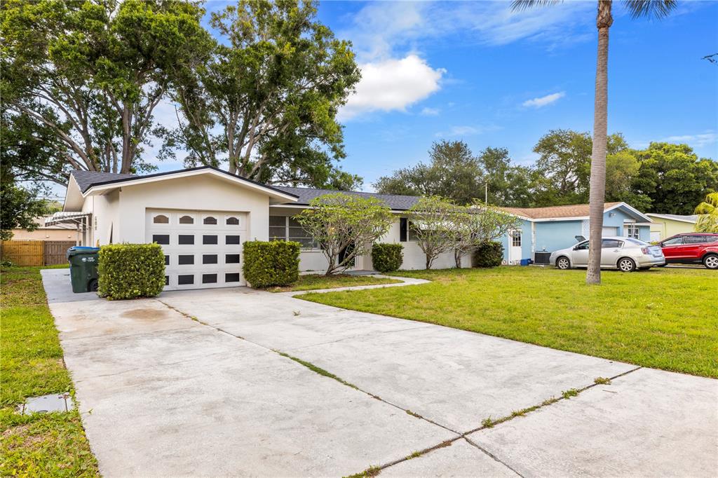 A single-story house with a white exterior, a garage, and a concrete driveway — 1820 PATLIN CIRCLE N, LARGO, FL