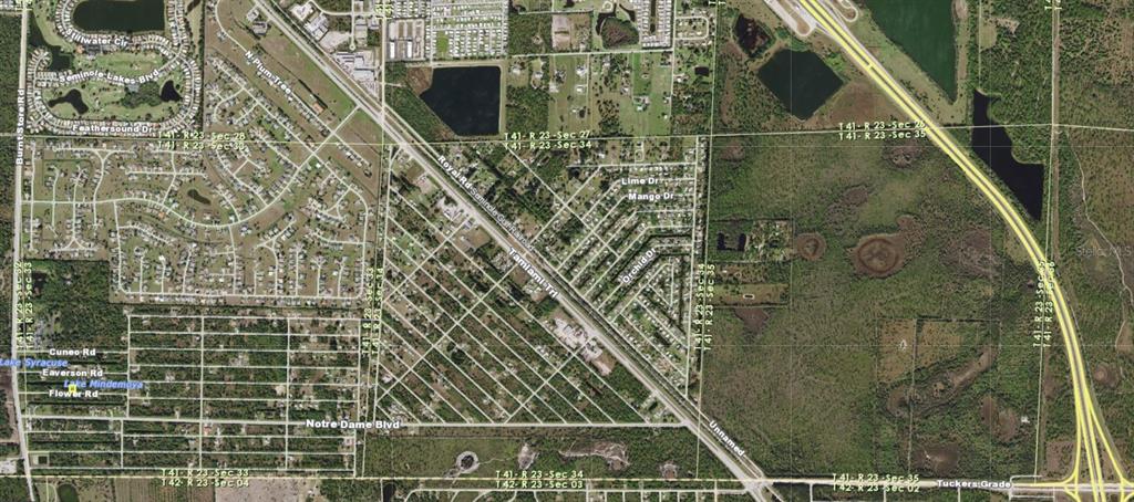 This is an aerial map view showing residential streets, undeveloped land, and highway infrastructure — 26074 FLOWER ROAD, PUNTA GORDA, FL