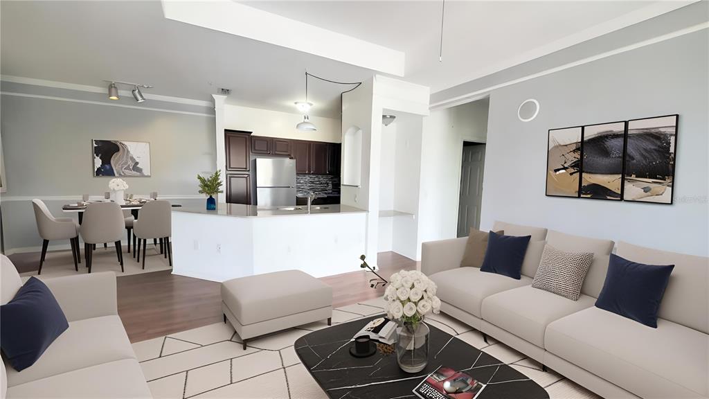 This open-concept living and dining area features a kitchen with dark cabinets and white counters — 6413 ASTOR VILLAGE AVENUE UNIT 315, ORLANDO, FL