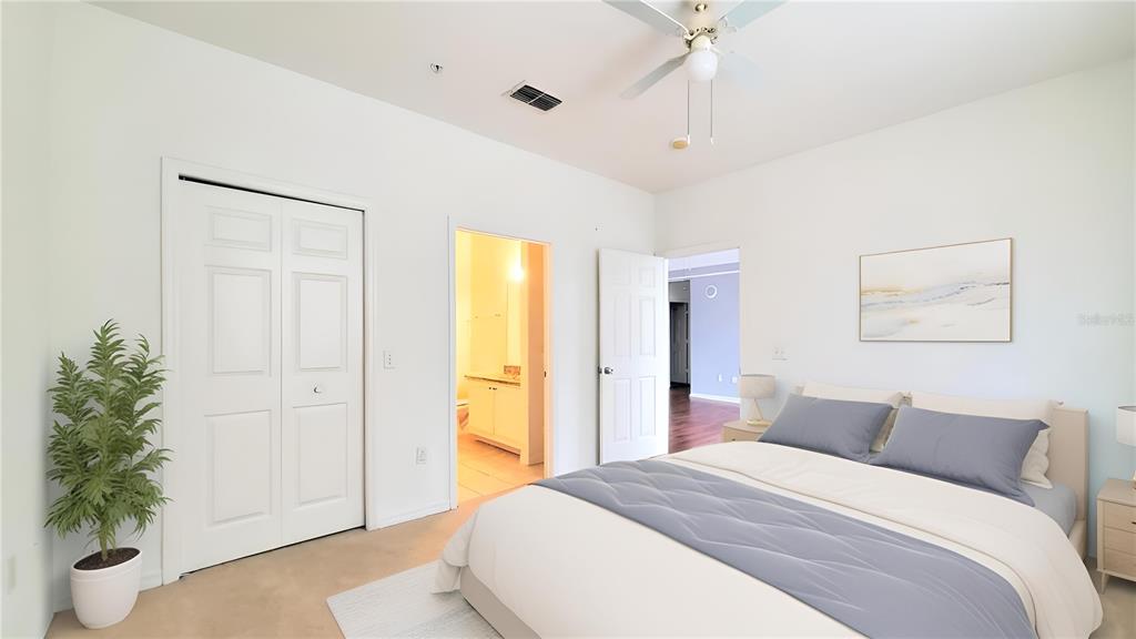 A bedroom features a bed with blue bedding, a closet, and an attached bathroom — 6413 ASTOR VILLAGE AVENUE UNIT 315, ORLANDO, FL