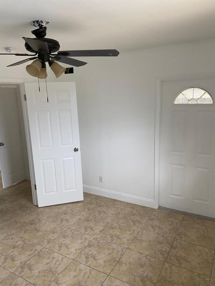 A room with tile flooring, a ceiling fan, a white door, and an exterior door — 18 Andros Road, Palm Springs FL 33461, PALM SPRINGS, FL