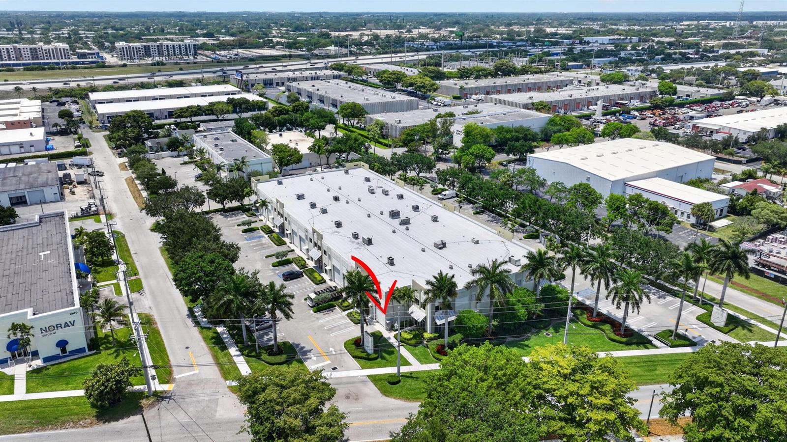 An aerial view shows a commercial building complex with parking lots and surrounding greenery — 1250 Wallace Drive # A, Delray Beach FL 33444, DELRAY BEACH, FL