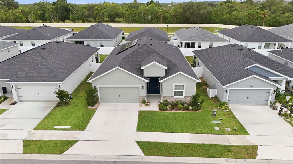 An aerial view shows a suburban house with a gray roof and light-colored siding — 2486 MATTERHORN TRAIL, DAVENPORT, FL