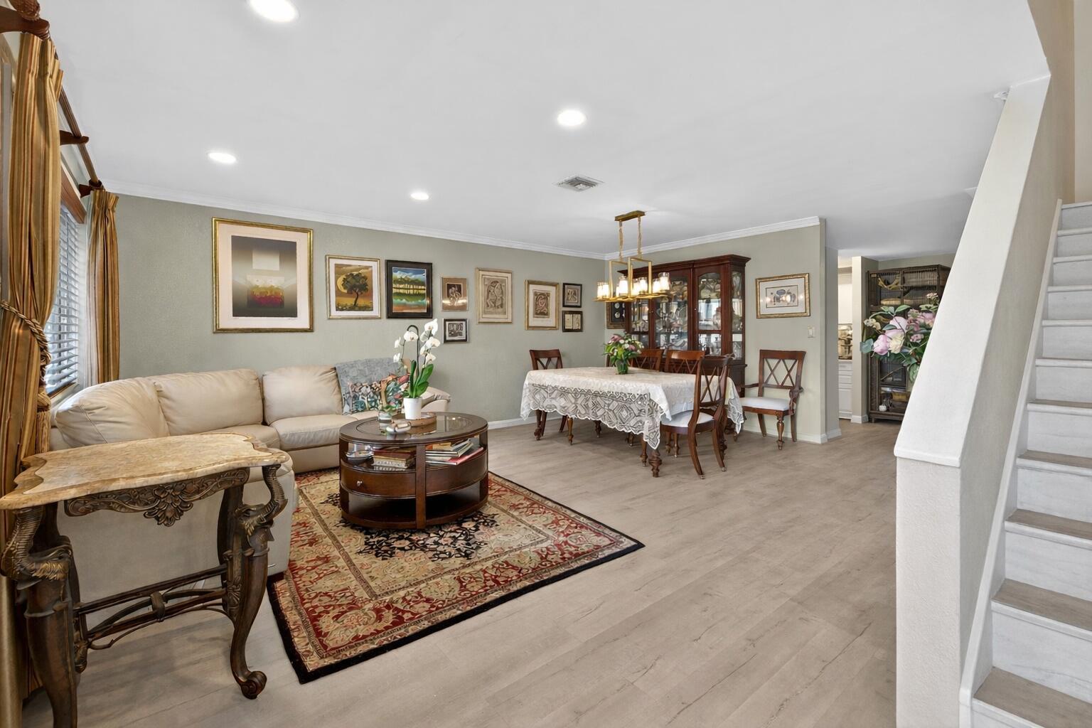 A living and dining area features light wood floors, a sectional sofa, and a gallery wall — 837 NW 47th Street, Deerfield Beach FL 33064, DEERFIELD BEACH, FL