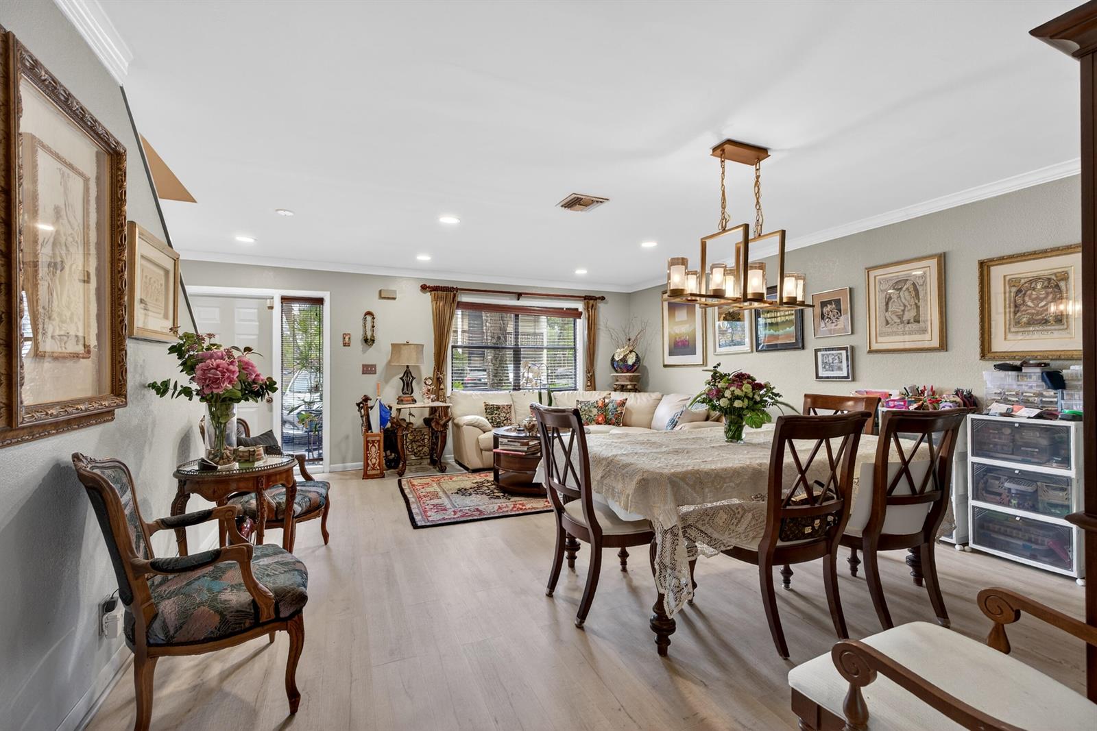A dining area with a chandelier and table flows into a living room with seating — 837 NW 47th Street, Deerfield Beach FL 33064, DEERFIELD BEACH, FL