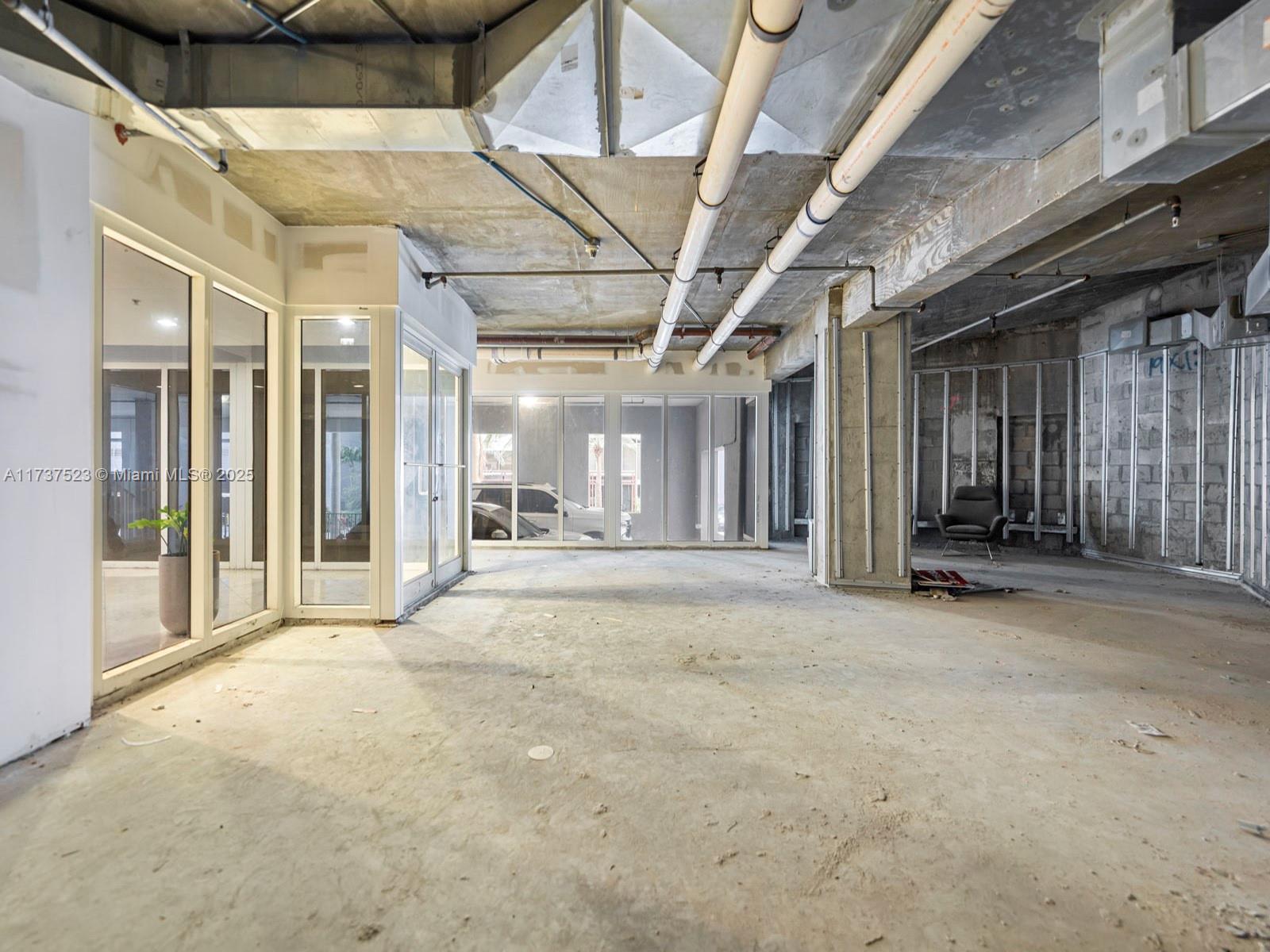 An unfinished commercial space features exposed concrete ceilings, industrial piping, and glass-walled office partitions — 170 SE 14th St, Miami FL 33131, MIAMI, FL
