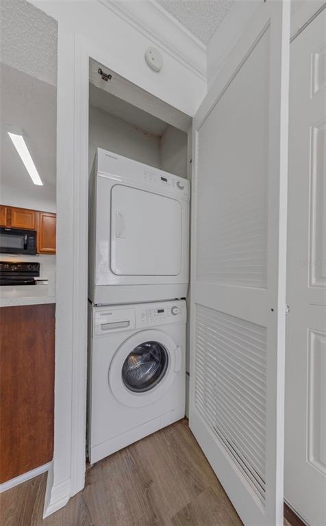 A stacked white Samsung washer and dryer unit sits inside a closet in a kitchen — 643 HAVEN PLACE UNIT 643, TARPON SPRINGS, FL