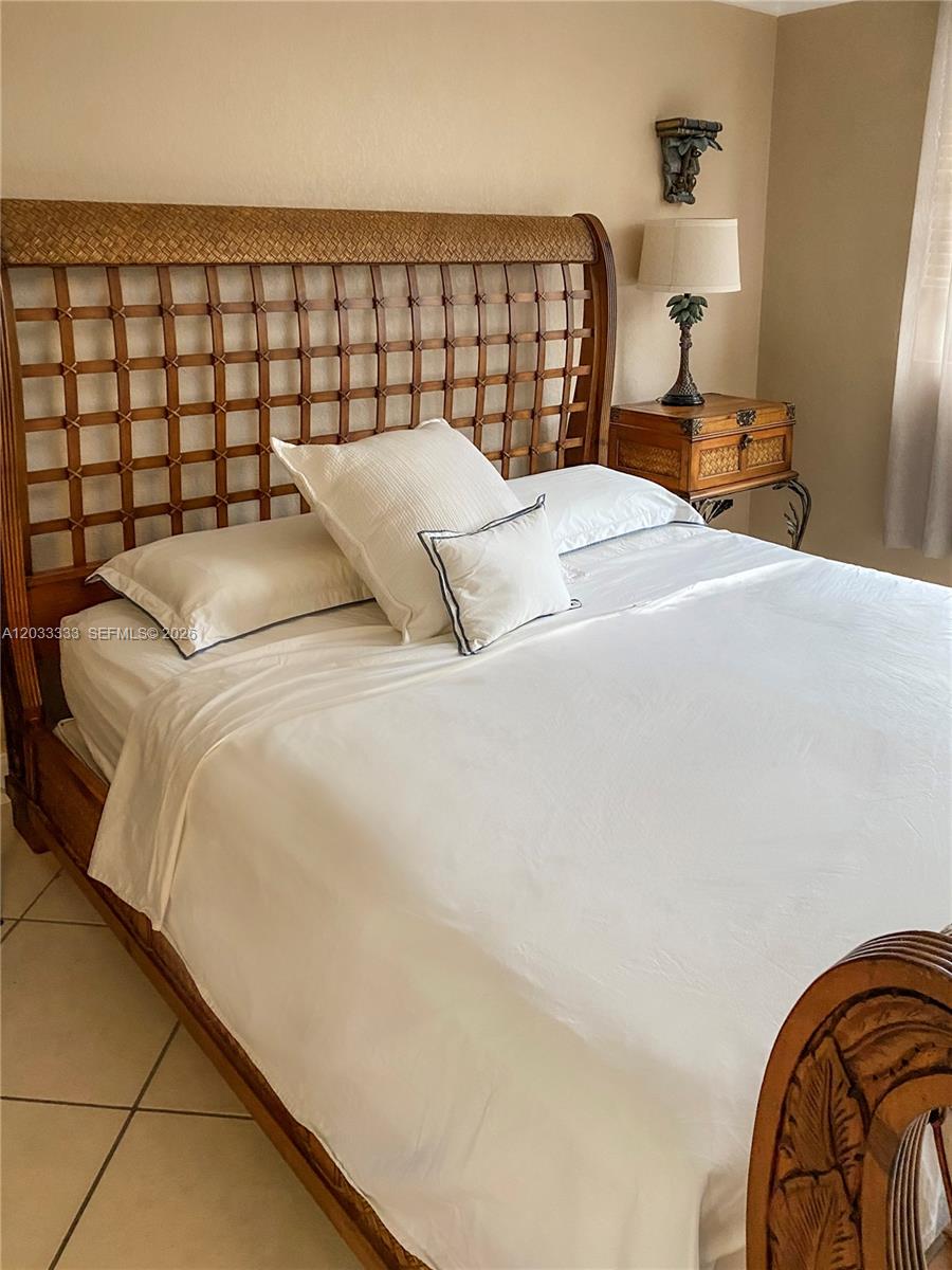 A living room features two beige sofas, two green armchairs, a glass coffee table, and pendant lighting — 9225 Collins Ave # 1206, Surfside FL 33154, SURFSIDE, FL
