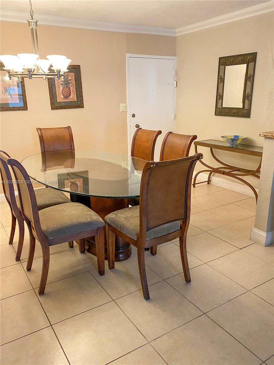 A living room features white sofas, a patterned armchair, tile floors, and a ceiling fan — 9225 Collins Ave # 1206, Surfside FL 33154, SURFSIDE, FL
