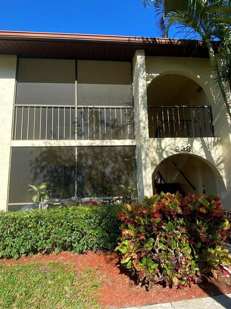 A two-story building exterior features a screened-in patio, arched entryways, and a landscaped front yard — 4835 Sable Pine Circle # A2, West Palm Beach FL 33417, WEST PALM BEACH, FL