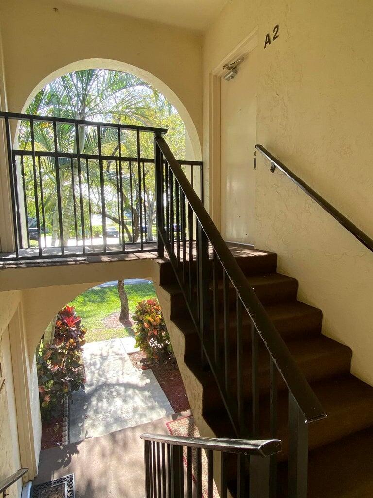 An outdoor staircase with a black metal railing leads to an apartment door labeled A2 — 4835 Sable Pine Circle # A2, West Palm Beach FL 33417, WEST PALM BEACH, FL