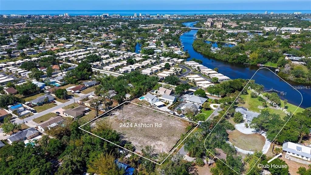 This aerial view shows a vacant lot and a nearby park area along a waterway — 2424 ASHTON ROAD, SARASOTA, FL
