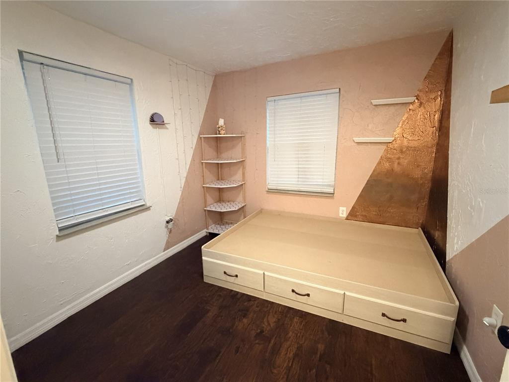 A bedroom features a built-in platform bed with storage drawers, a corner shelf, and textured walls — 1707 W COMANCHE AVENUE, TAMPA, FL
