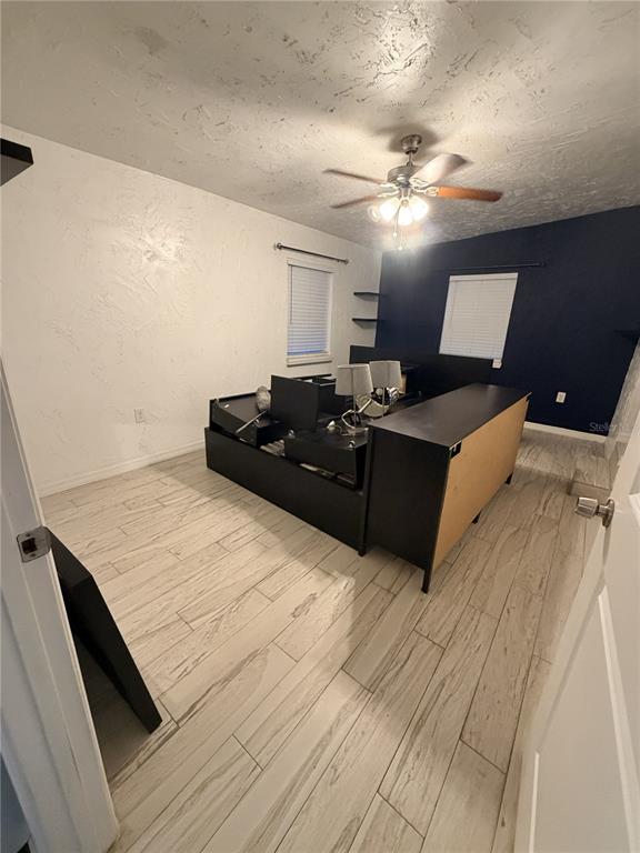 A bedroom features wood-look tile flooring, a ceiling fan, and a dark blue accent wall — 1707 W COMANCHE AVENUE, TAMPA, FL