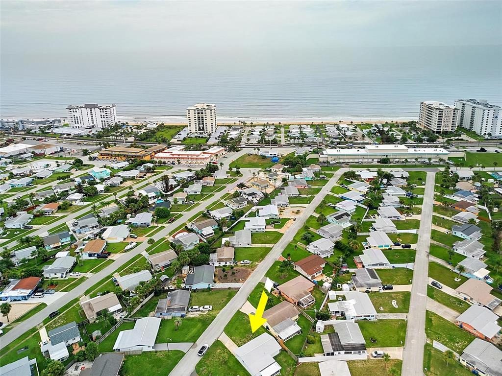 An aerial view shows a residential neighborhood with a yellow arrow pointing to a house — 22 BEECHWOOD DRIVE, ORMOND BEACH, FL