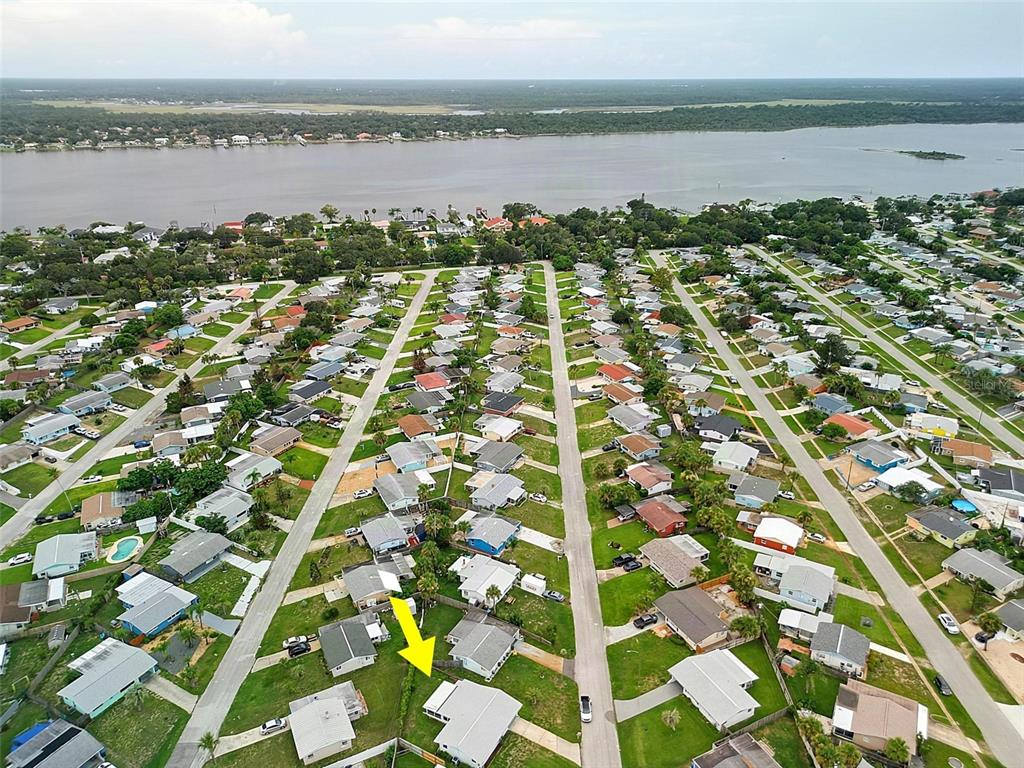 An aerial view shows a residential neighborhood with a yellow arrow pointing to a specific house — 22 BEECHWOOD DRIVE, ORMOND BEACH, FL