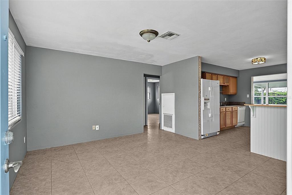 An open-concept living and kitchen area features gray walls, tile flooring, and wood cabinets — 22 BEECHWOOD DRIVE, ORMOND BEACH, FL
