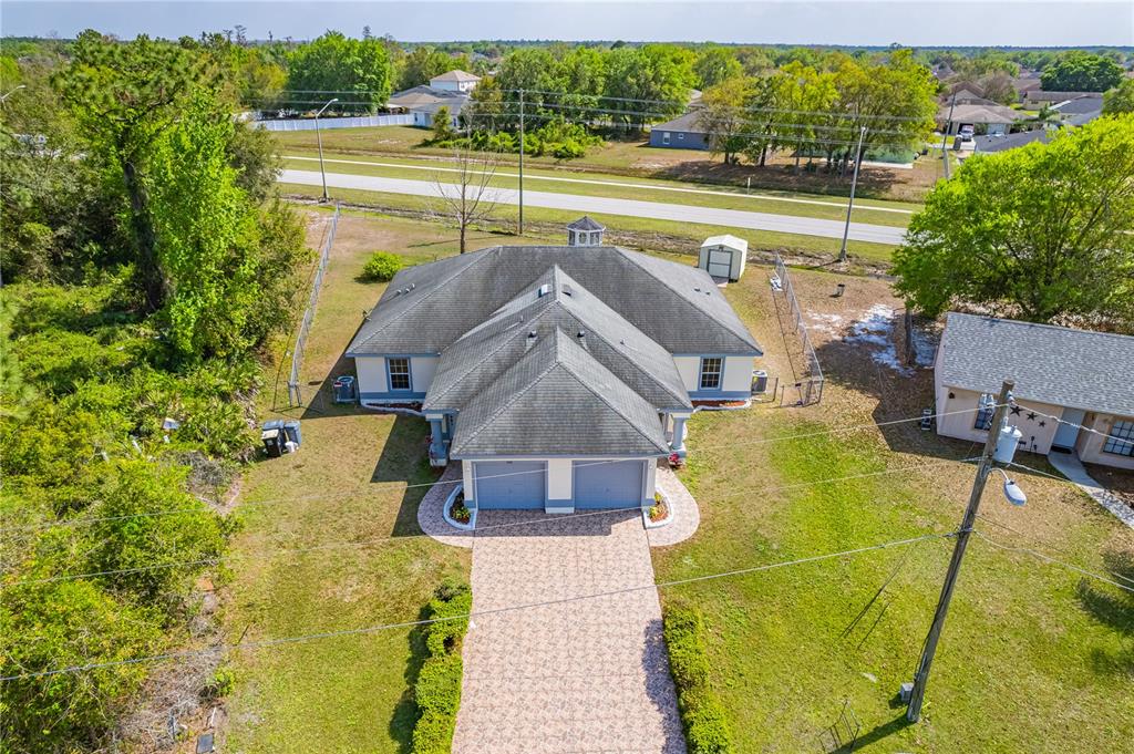 An aerial view shows a single-story house with a two-car garage and a paved driveway — 746-748 MINK CT, POINCIANA, FL