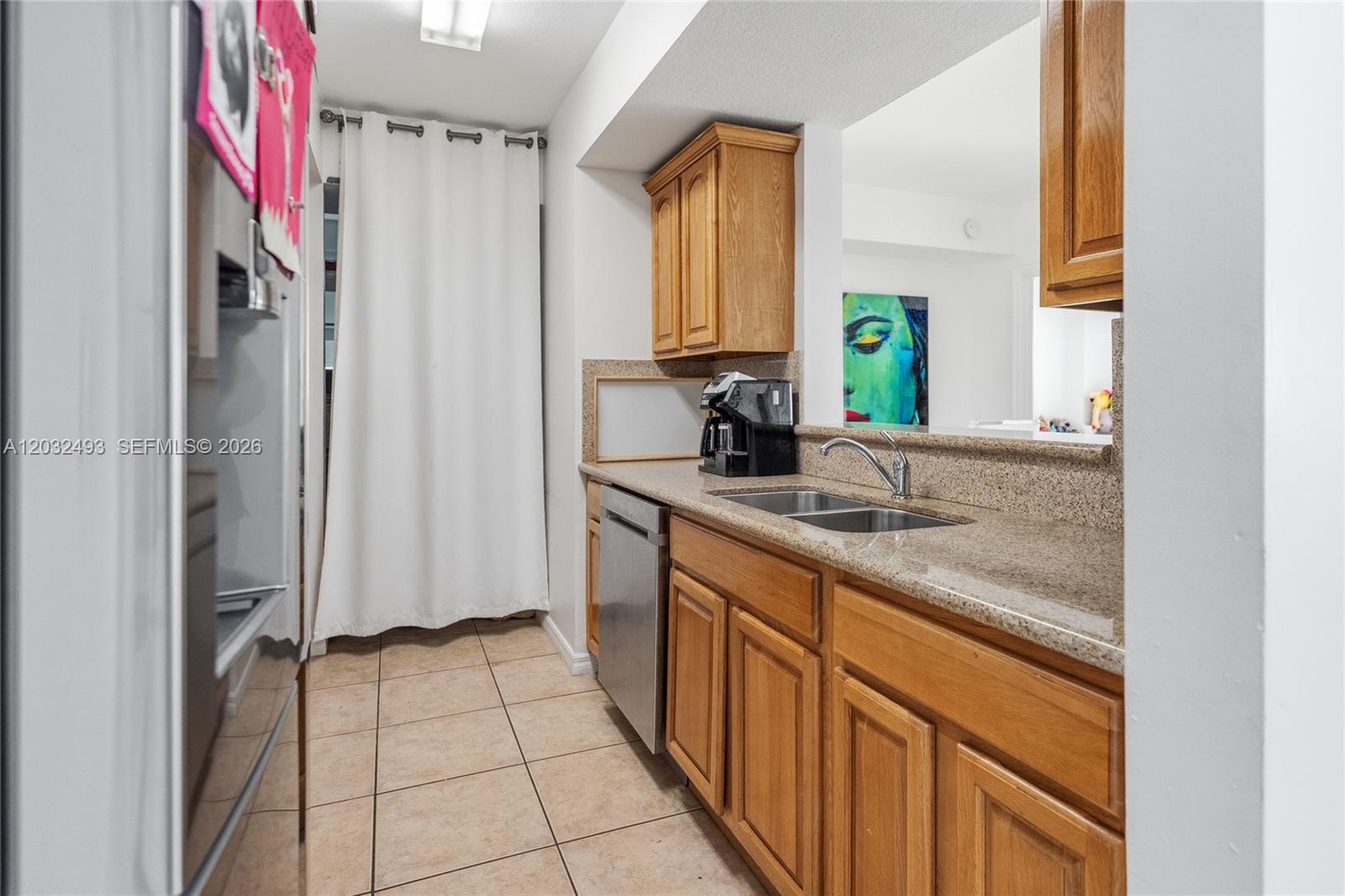 A kitchen features wooden cabinets, granite countertops, a stainless steel dishwasher, and tile flooring — 4242 NW 2nd St # 1001, Miami FL 33126, MIAMI, FL