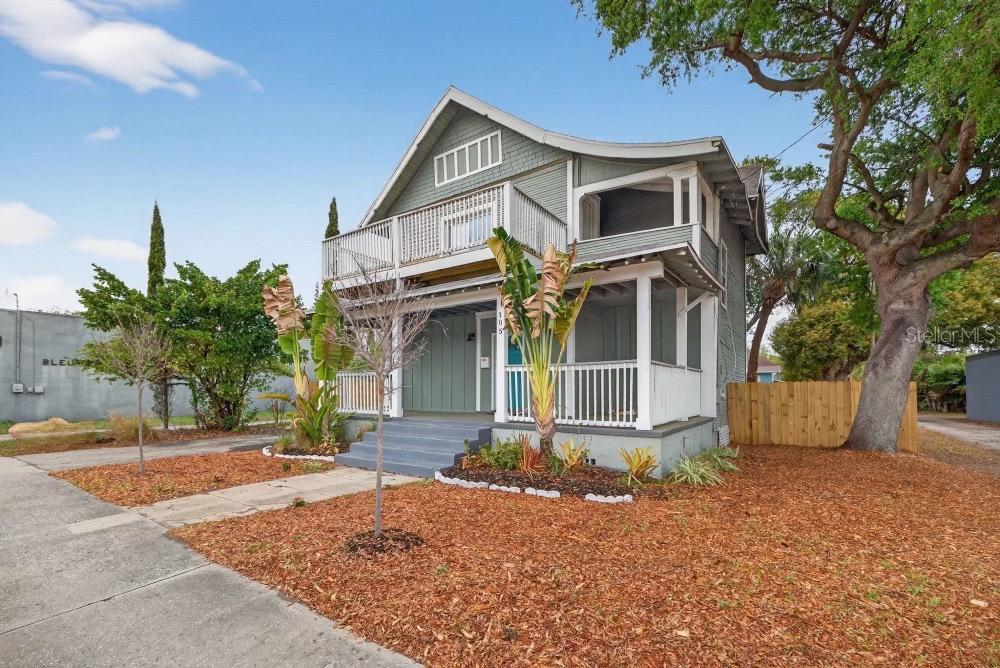 A two-story house with a front porch, a second-floor balcony, and a wood fence — 105 W COLUMBUS DRIVE, TAMPA, FL