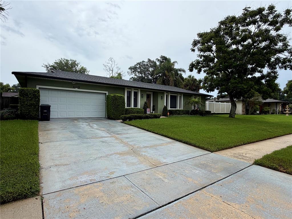A single-story house with a green exterior, a two-car garage, and a concrete driveway — 1105 DORIS STREET, ALTAMONTE SPRINGS, FL
