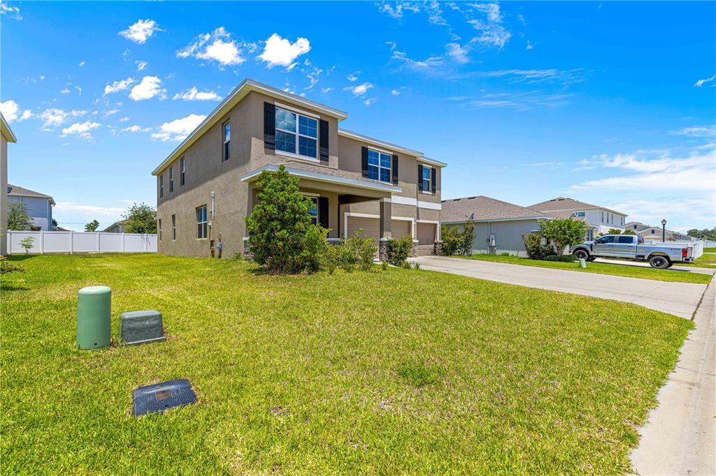 A two-story house with a tan exterior, a two-car garage, and a large front lawn — 8142 SW 59TH AVENUE, OCALA, FL