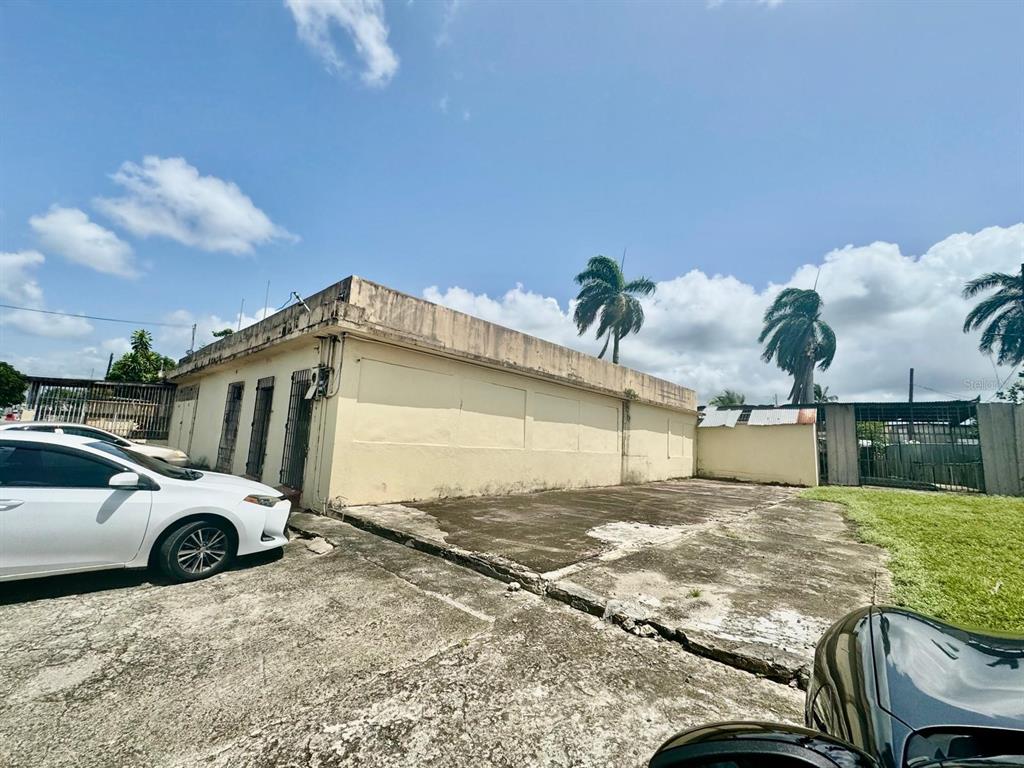 A single-story commercial building with a concrete parking lot under a bright blue sky — 51 AVENIDA TROCHE, CAGUAS, PR