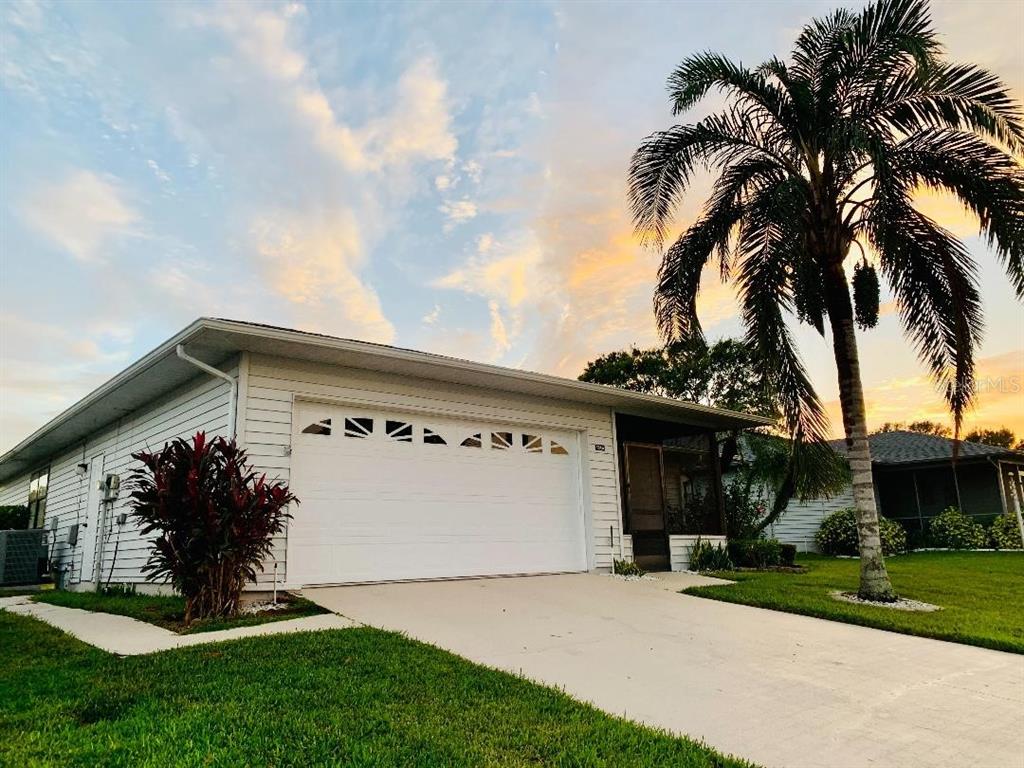 A white house with a garage and a palm tree under a sunset sky — 1846 MASTERS LANE, LAKELAND, FL