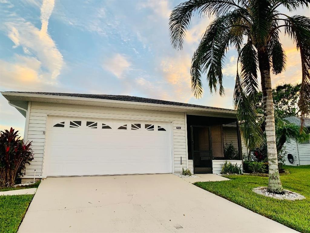 A single-story house with white siding, a two-car garage, and a palm tree in front — 1846 MASTERS LANE, LAKELAND, FL