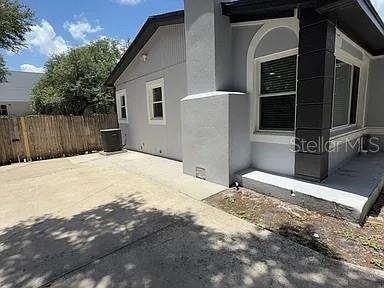 The exterior of a gray house features a concrete patio, a chimney, and a fence — 270 W PINELOCH AVENUE, ORLANDO, FL