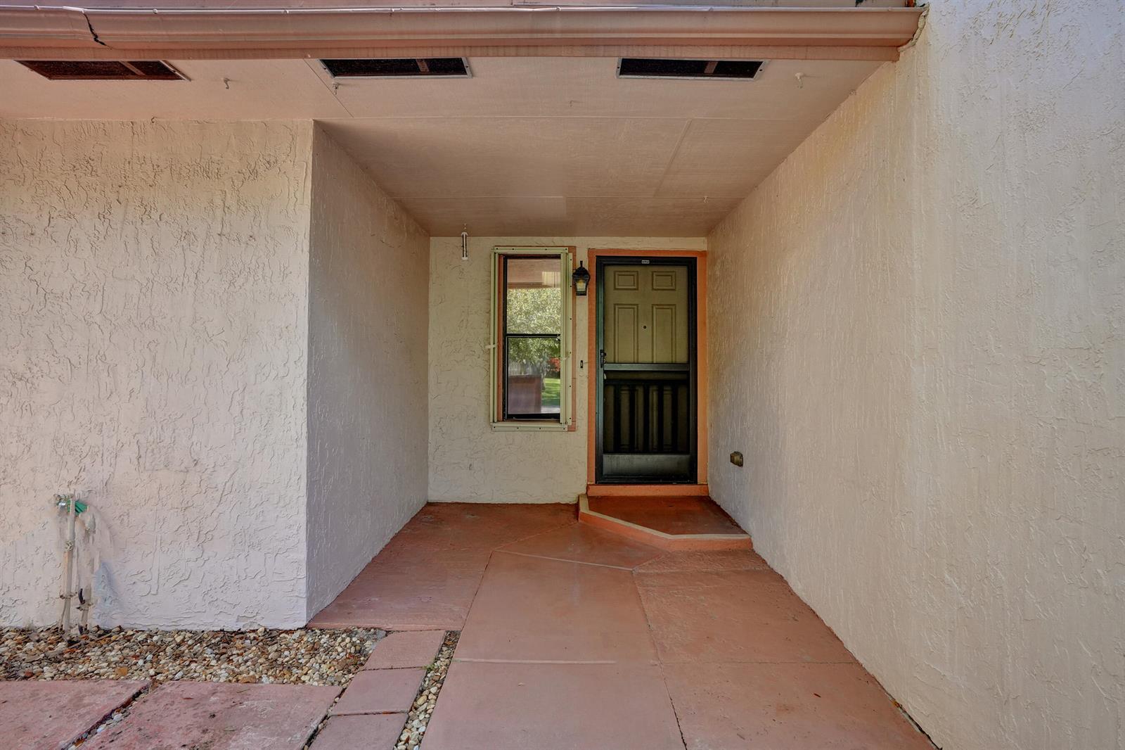 A covered entryway with a concrete floor, a single window, and a front door — 78 Mayfair Lane # 78, Boynton Beach FL 33426, BOYNTON BEACH, FL