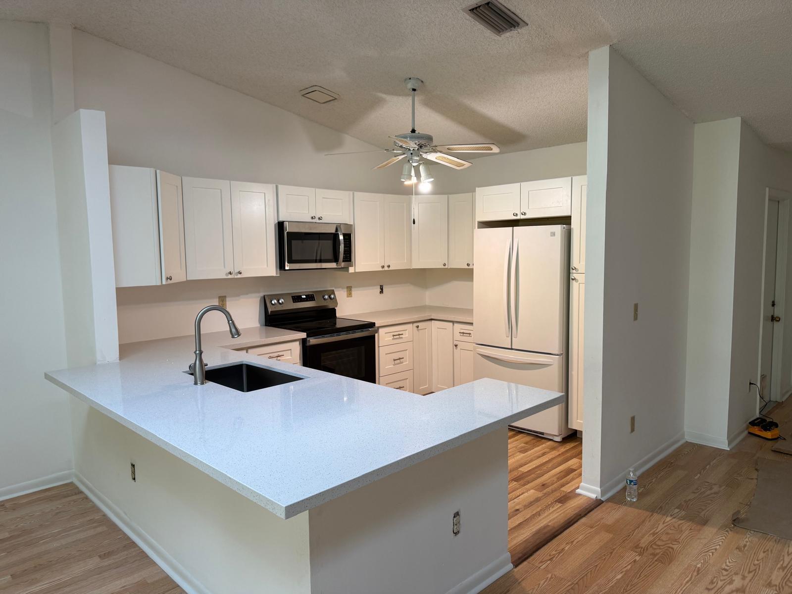 A kitchen with white cabinets, light countertops, a stainless steel microwave, and a white refrigerator — 78 Mayfair Lane # 78, Boynton Beach FL 33426, BOYNTON BEACH, FL