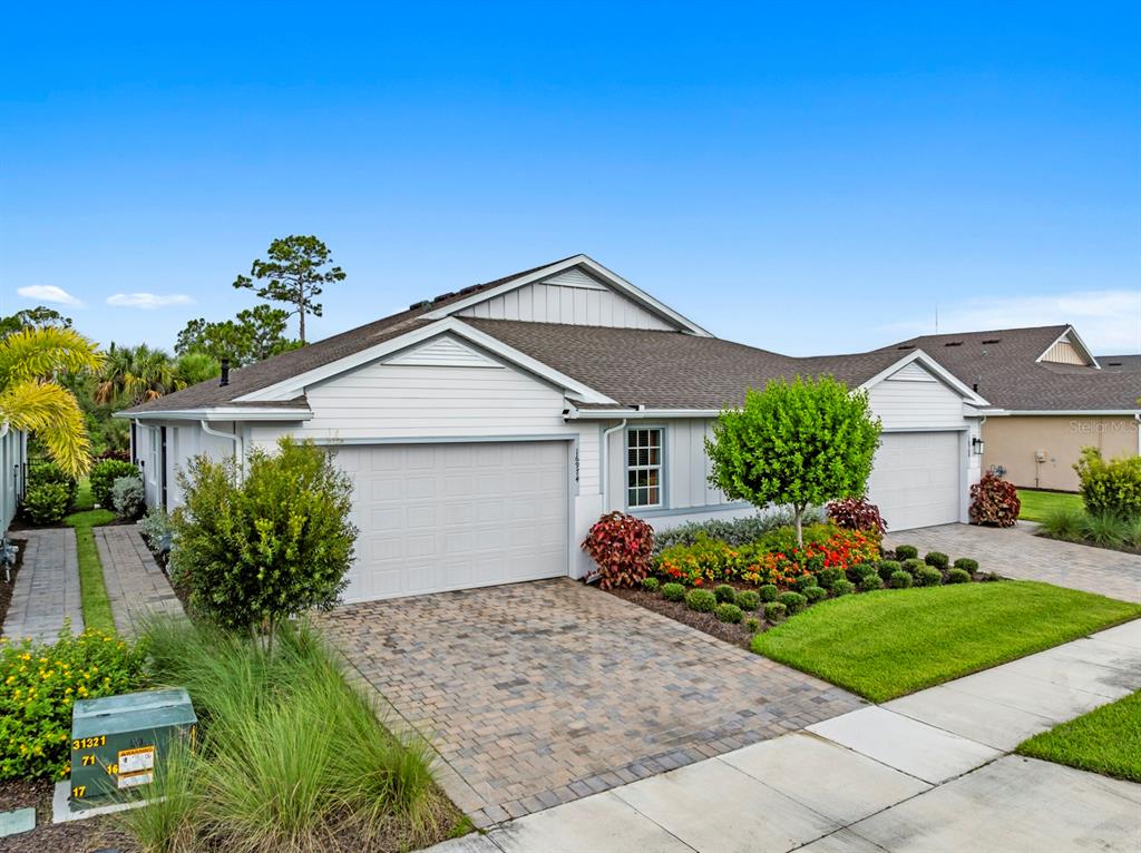 A single-story house with a light-colored exterior, a two-car garage, and a paved driveway — 16974 HAWK COURT, PUNTA GORDA, FL
