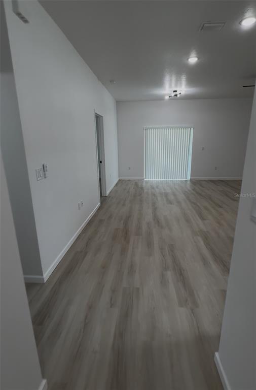 An interior view of a room with light wood-look flooring and a sliding glass door — 14665 SW 22ND PLACE, OCALA, FL
