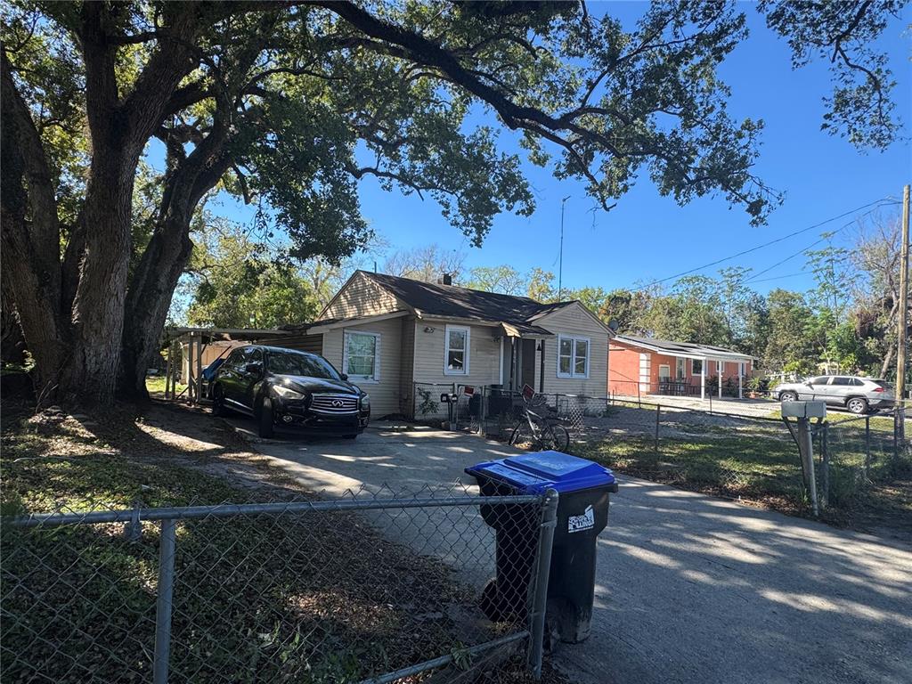 A single-story house with a driveway, a carport, and a large tree in the front yard — 1500 43RD STREET, ORLANDO, FL