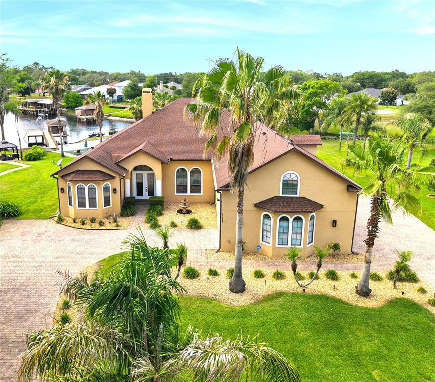 An aerial view of a tan, single-story house with a brown roof and palm trees — 11325 PRESTON COVE ROAD, CLERMONT, FL
