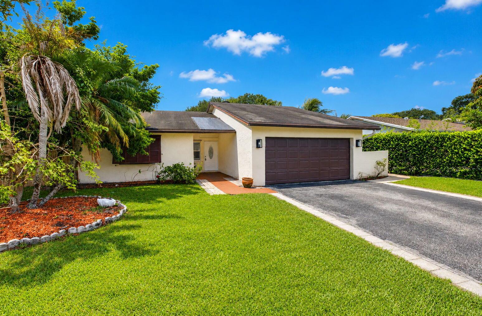 A single-story house with a brown garage door, a paved driveway, and a front lawn — 9510 Affirmed Lane, Boca Raton FL 33496, BOCA RATON, FL