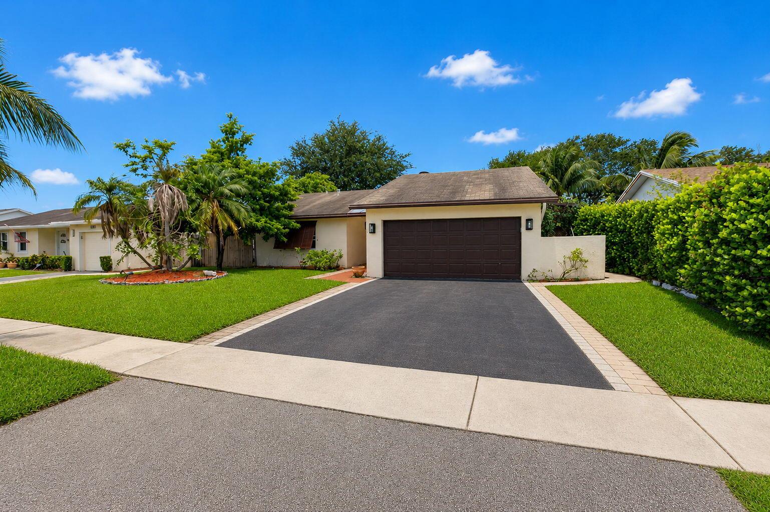 A single-story house with a brown garage door, paved driveway, and green lawn — 9510 Affirmed Lane, Boca Raton FL 33496, BOCA RATON, FL