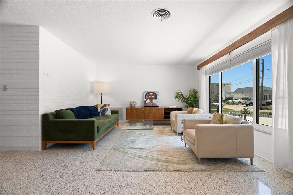 A living room features a green sofa, two cream armchairs, and a large window — 2671 W BAY ISLE DRIVE SE, ST PETERSBURG, FL