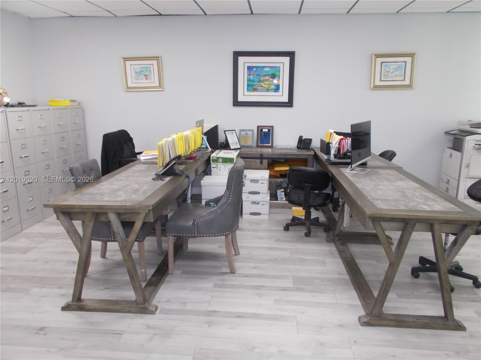 An office space features two long wooden desks, gray chairs, and gray filing cabinets — 13055 SW 42nd St # 204, Miami FL 33175, MIAMI, FL
