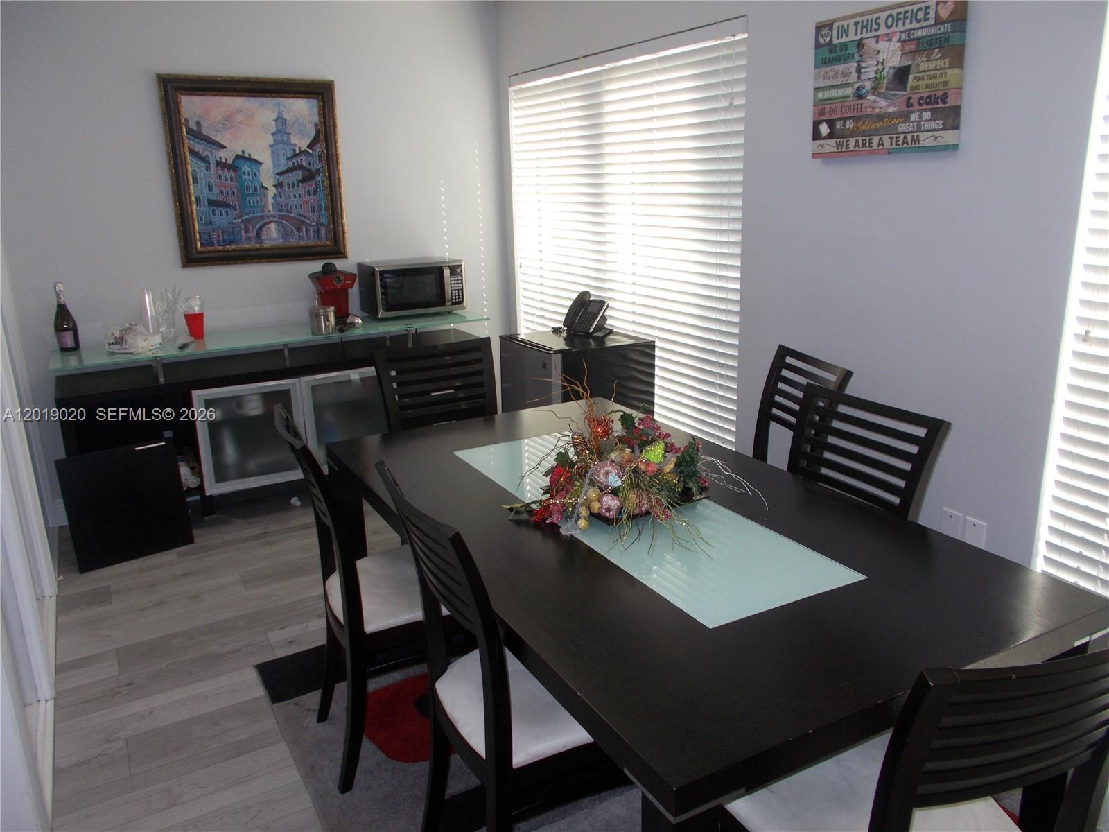A dining room features a dark wood table, matching chairs, and a glass-topped sideboard — 13055 SW 42nd St # 204, Miami FL 33175, MIAMI, FL