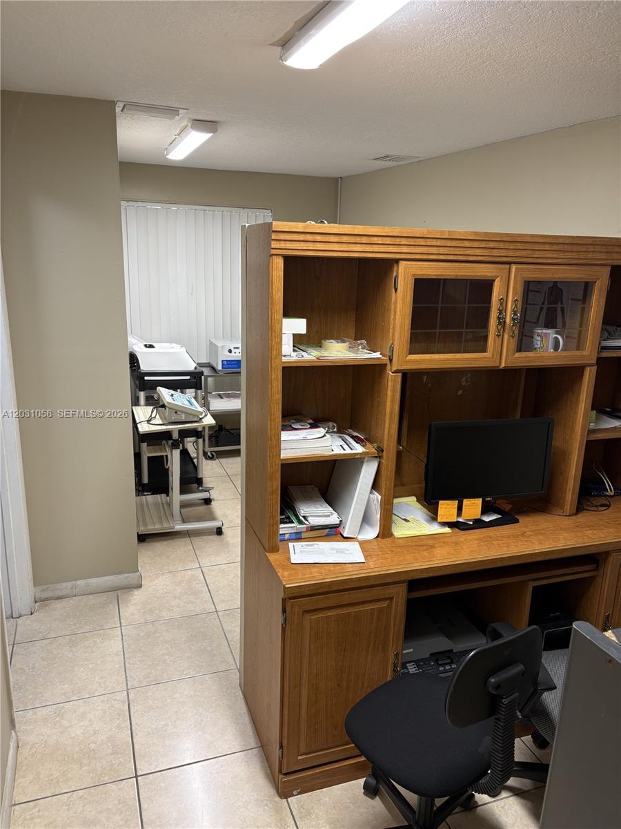 An office space features a wooden desk hutch and a tiled floor leading to a back area — 1750 W 39th Pl # 1007, Hialeah FL 33012, HIALEAH, FL